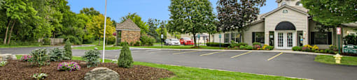 a flagpole with an american flag in front of a building with a parking lot