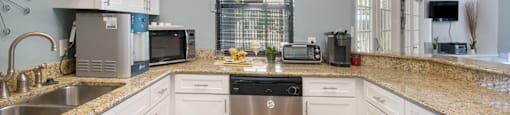 a kitchen with white cabinets and a granite counter top
