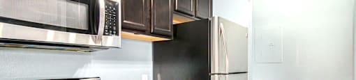 a kitchen with black cabinets and stainless steel appliances