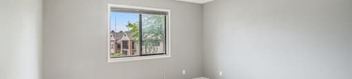 a bedroom with gray walls and a large window