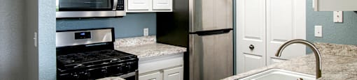 a kitchen with white cabinets and blue walls