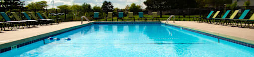a large swimming pool with chairs around it
