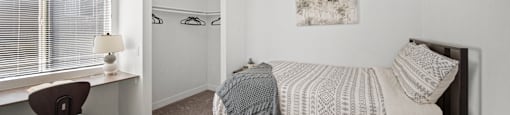 A bedroom with a bed, a desk, and a ceiling fan.