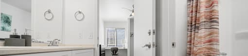 A bathroom with a toilet, sink, and mirror.