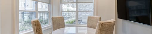 A dining room with a round table and chairs.
