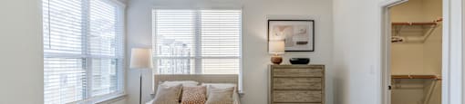 A bedroom with a bed, dresser, and window.