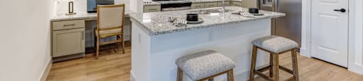 A kitchen with a white counter top and a sink.