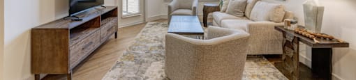 A living room with a television, couch, and a rug.