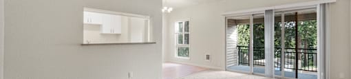 an empty living room with sliding glass doors to a patio