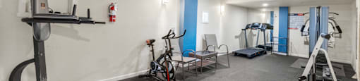 a gym with weights and exercise equipment in a room with white walls