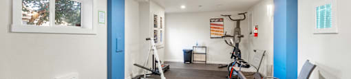 a gym with treadmills and exercise equipment in a room with a window