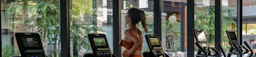 a woman walking on a treadmill in a gym at Arrowwood Apartments, North Bethesda