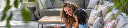 a mother and daughter sitting on a couch in a garden at Arrowwood Apartments, North Bethesda