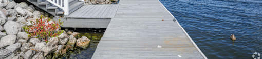 a dock with a house on the water at Lakeshore Pointe Apartment Homes, Brandon, 39047