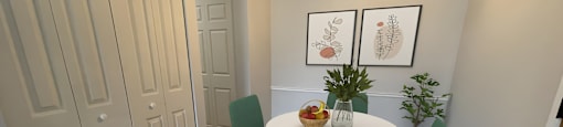 a dining area with a round table and four green chairs