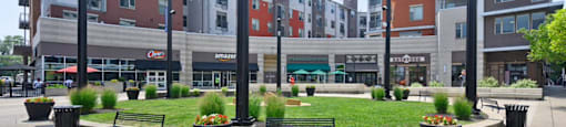 a park with benches and grass in front of a building