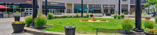 a park with a grassy area and buildings in the background