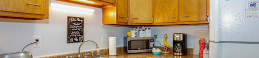 A kitchen with wooden cabinets and a white fridge.