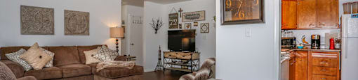 A living room with a grey coffee table and brown couches.
