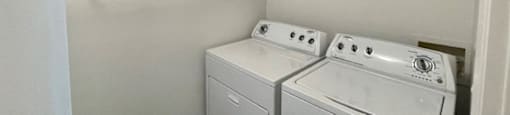 A small laundry room with a washer and dryer.