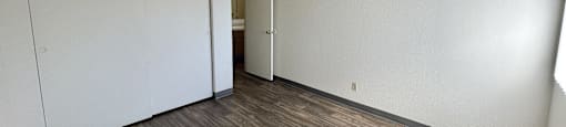 A room with a sliding door and wood flooring.
