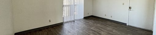 A room with wooden flooring and white walls.