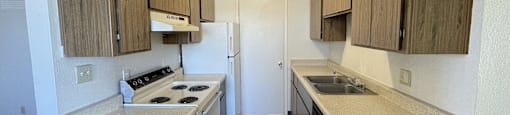 A kitchen with wooden cabinets and a white stove top oven.