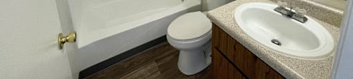 A white bathroom with a toilet, sink, and bathtub.