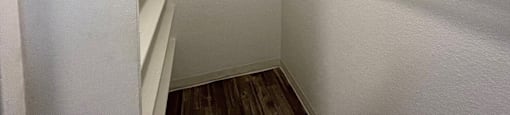 A white closet with shelves and a door.