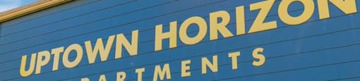 A blue building with the words "Uptown Horizon Apartments" on it.