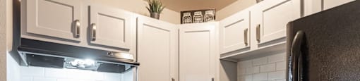 A kitchen with a black stove top oven and a black refrigerator.