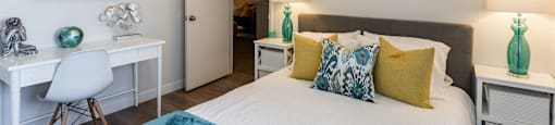 A bedroom with a bed, desk, and chair.