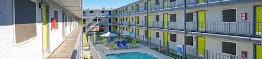 A pool is surrounded by apartment buildings.