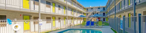 A swimming pool is surrounded by apartment buildings.