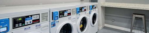 A laundry room with washing machines and a laundry sign on the wall.