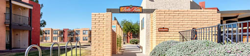 A pathway leads to a building entrance with a metal railing on the left.