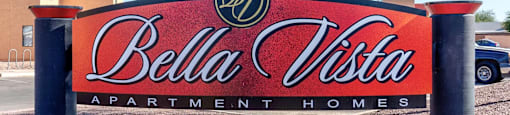 A sign for Bella Vista Apartment Homes is displayed in front of a building.