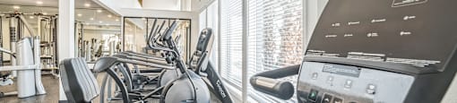 A gym with treadmills, elliptical machines, and other exercise equipment.
