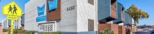 A modern building with a sign that reads "3450" and a school crossing sign in front of it.