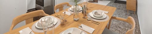 A dining room with a wooden table set for a meal.