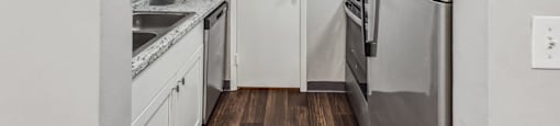 A kitchen with a refrigerator, sink, and cabinets.