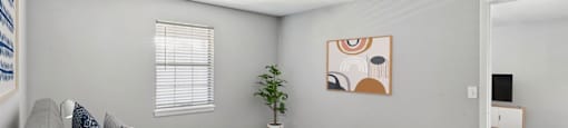 A bedroom with a bed, a couch, and a plant.