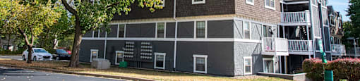 A large grey building with a tree in front of it.