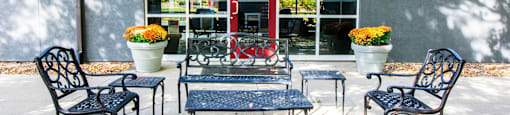 A patio with a table and chairs with a house in the background.