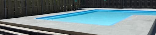 A refreshing swimming pool surrounded by lounge chairs at Cedar Ridge Apartments.