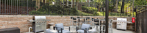 a patio with a table and chairs in front of a brick wall