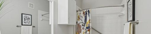 A bathroom with a white toilet, sink, and shower.