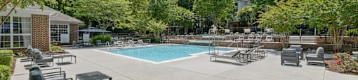 a swimming pool with chaise lounge chairs and tables