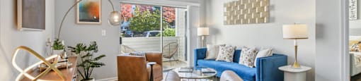 A living room with a blue couch and a lamp.