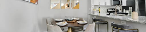 A modern kitchen with a dining table and chairs.